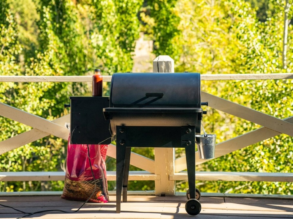 Traeger Tailgater 20 style portable pellet grill with folding legs on a wooden deck