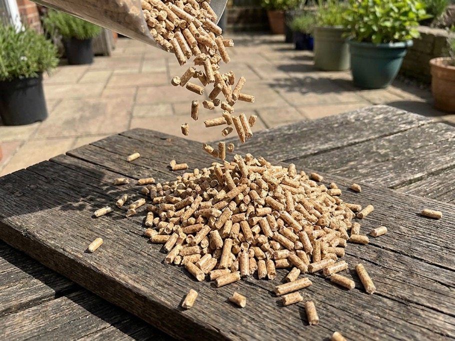 Smoky and fruitwood blend pellets poured onto a rustic wooden board