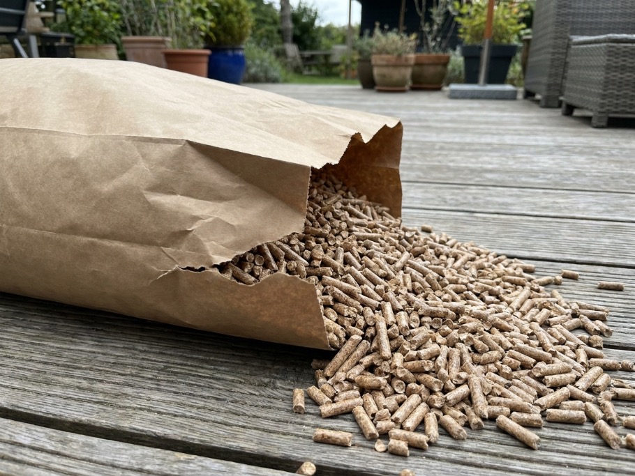 Hardwood blend pellets spilling from a torn bag corner